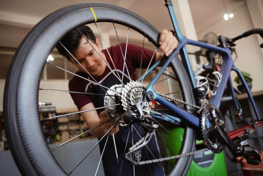 Expert dans un atelier de réparation de vélo à Montpellier qui examine un système de chaîne endommagé.